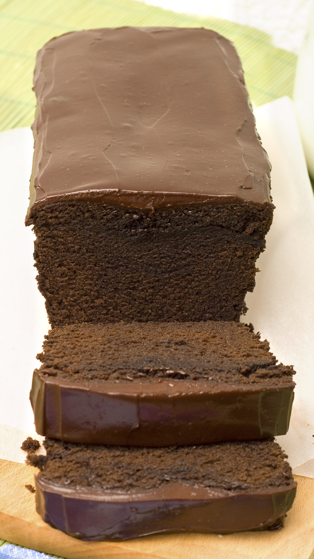 Chocolate Pound Cake recipe with Chocolate Ganache on a white parchment paper.