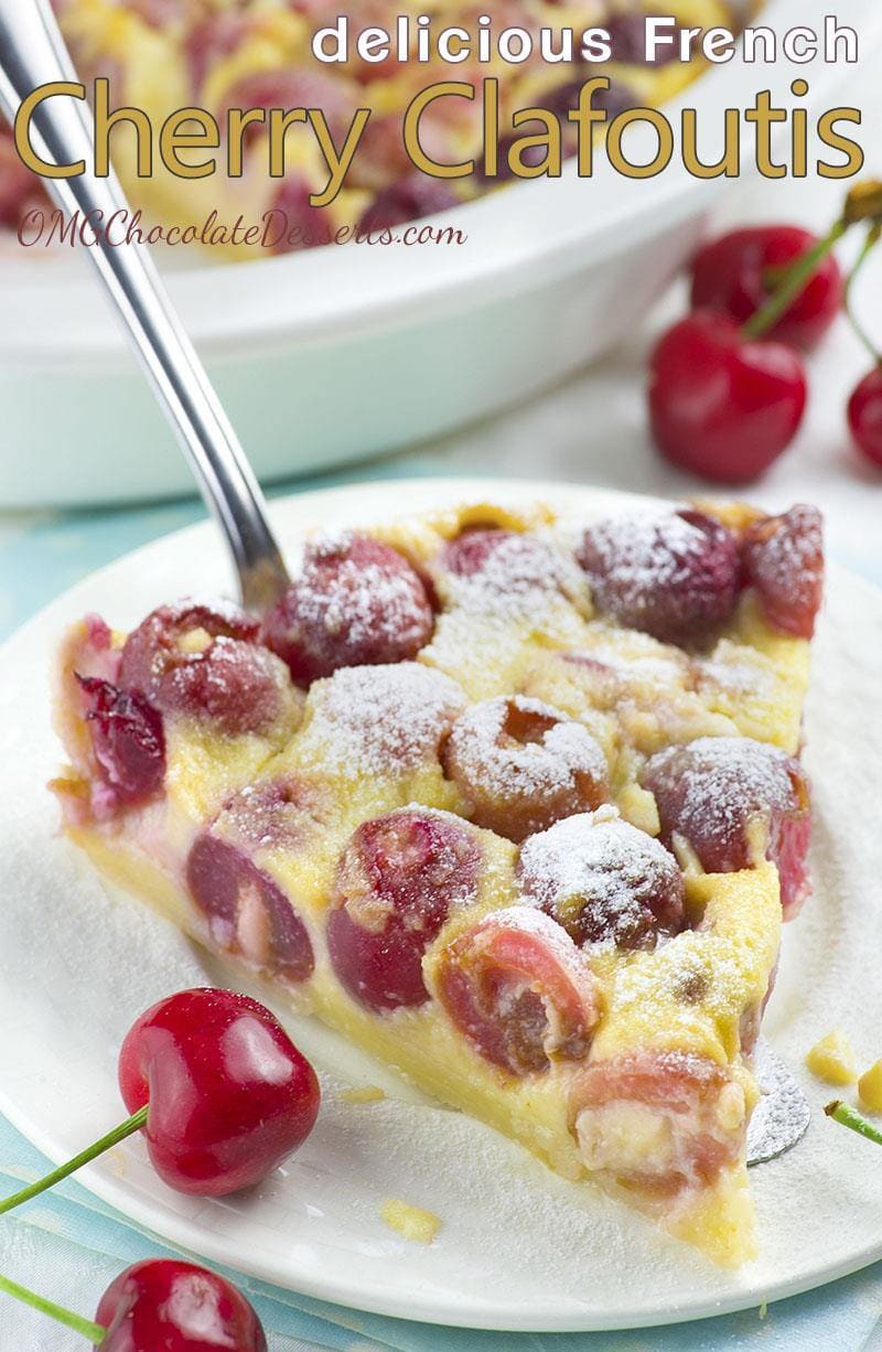 Piece of Cherry Clafoutis on white plate dusted with powdered sugar.