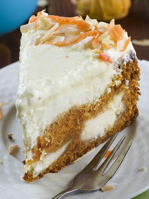 piece of Carrot Cake Cheesecake served on white plate.