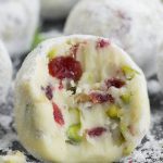 Cranberry and Pistachio White Chocolate Truffle with a bite taken out of it
