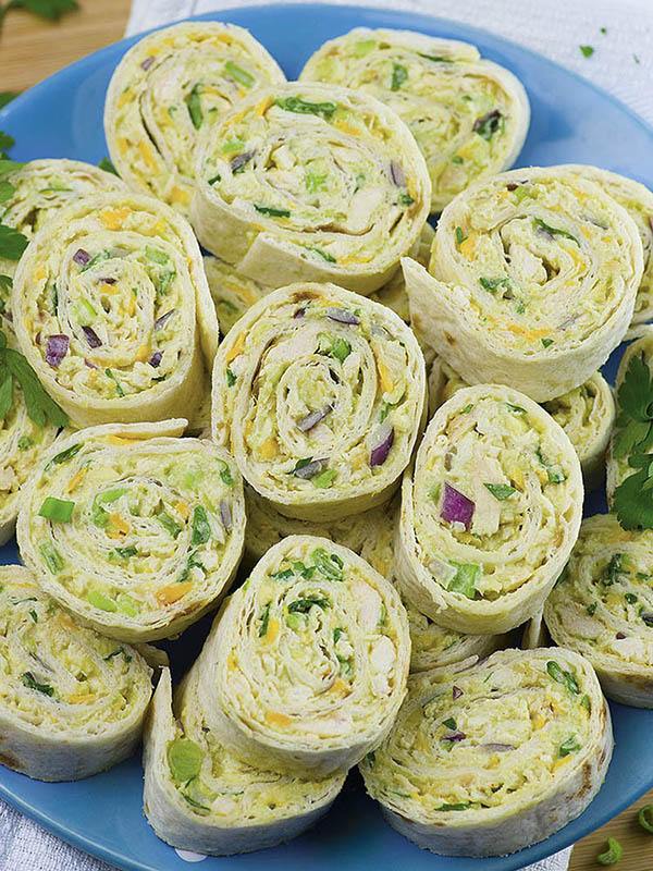 Bunch of Chicken Avocado Salad Rollups on a blue plate.