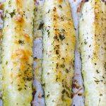 Three pieces of Baked Parmesan Zucchini on a baking paper.
