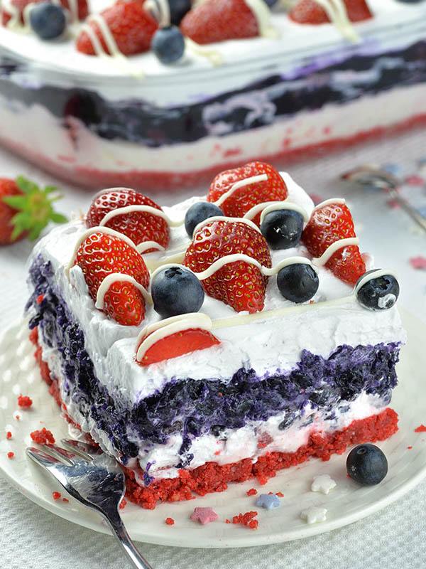 Piece of Summer Berry Lasagna on a white plate with fork.