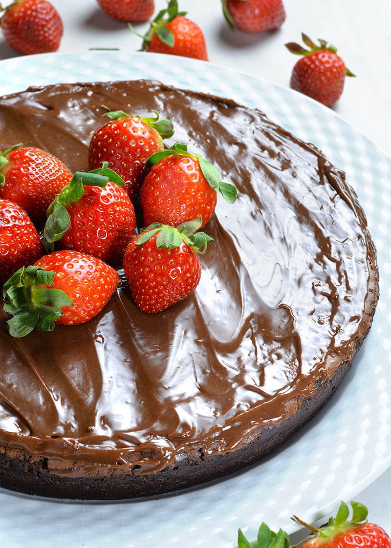 Whole Flourless Chocolate Cake with couple of strawberries.
