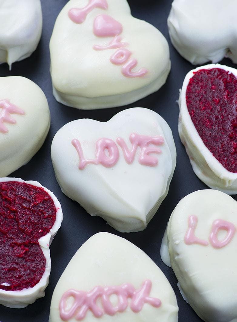 Bunch of Red Velvet Cake Valentine's Hearts on a black background.