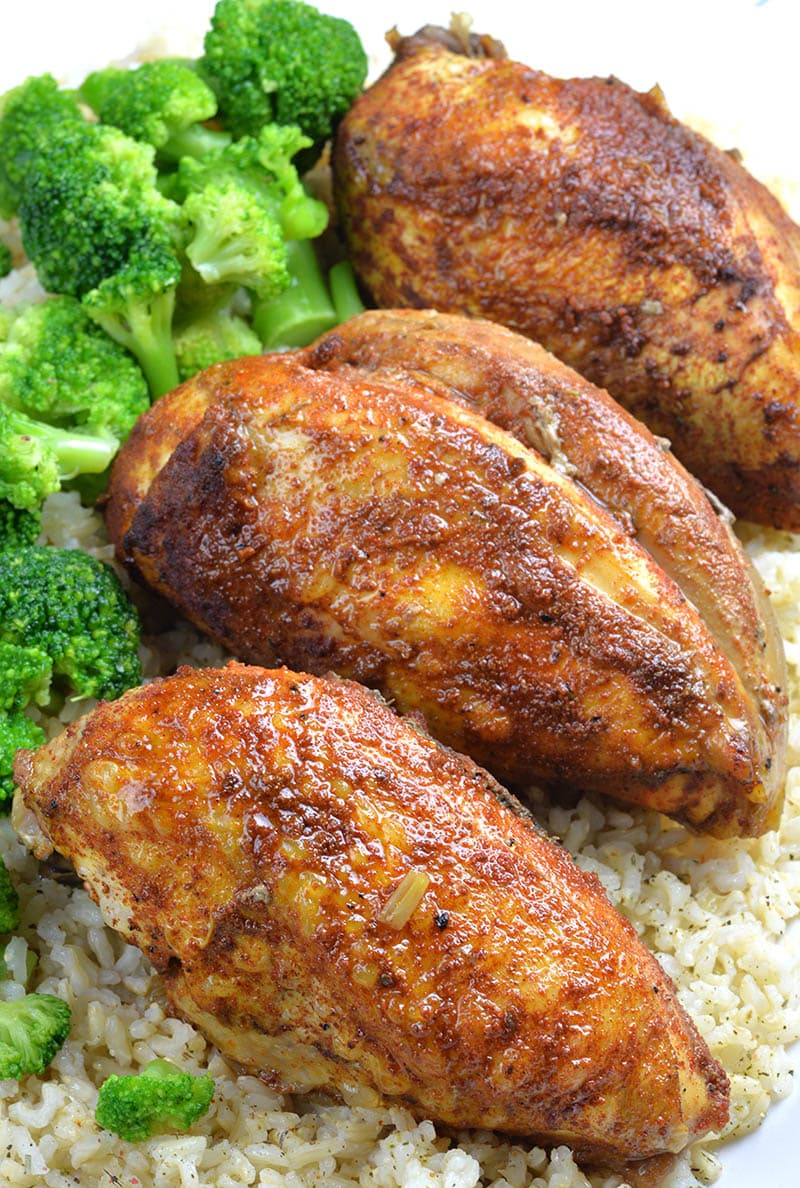 Three pieces of Healthy Slow Cooker Chicken Breasts on rice and broccoli.