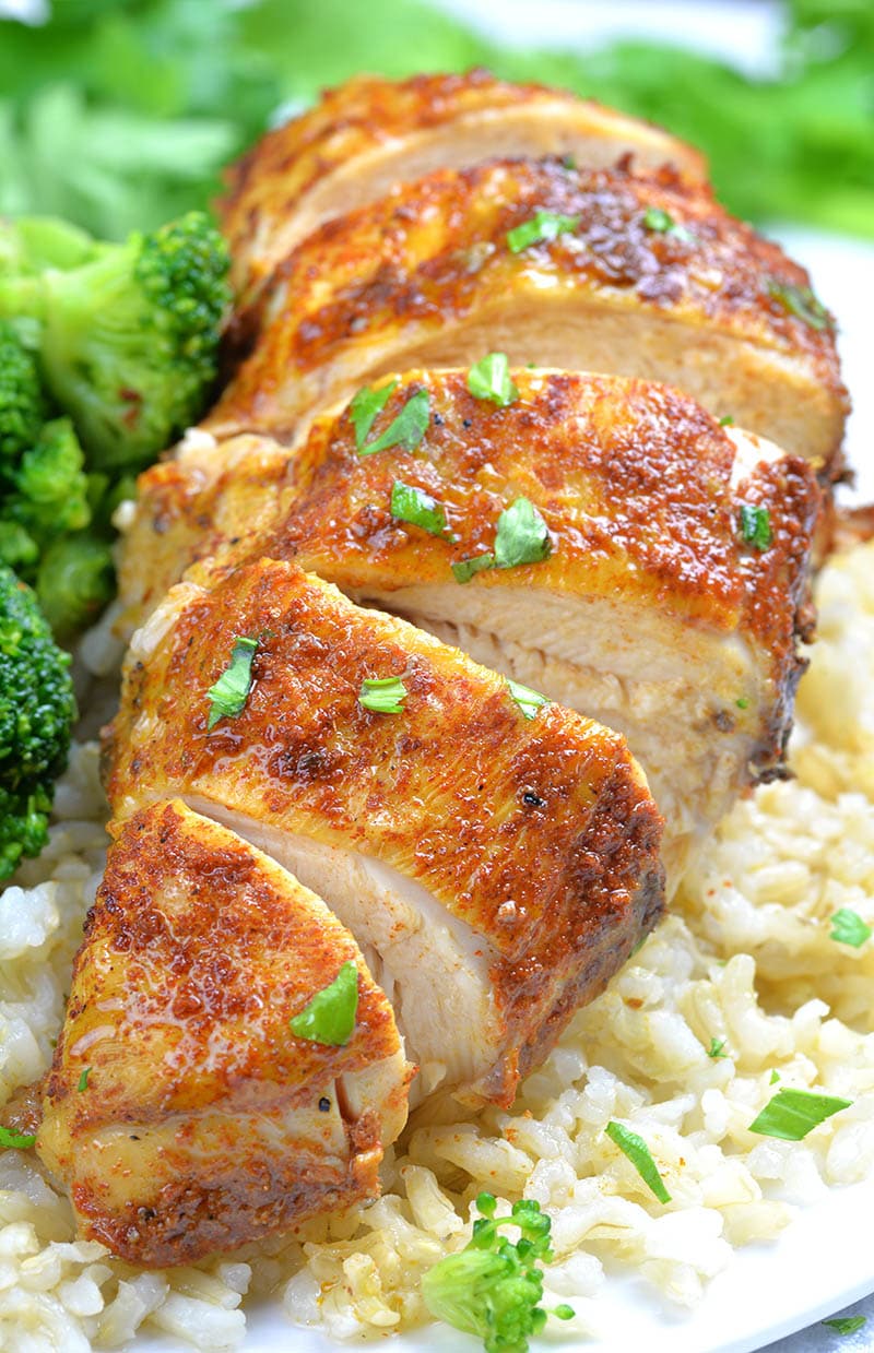 Cut piece of Healthy Slow Cooker Chicken Breast on a plate with rice. 