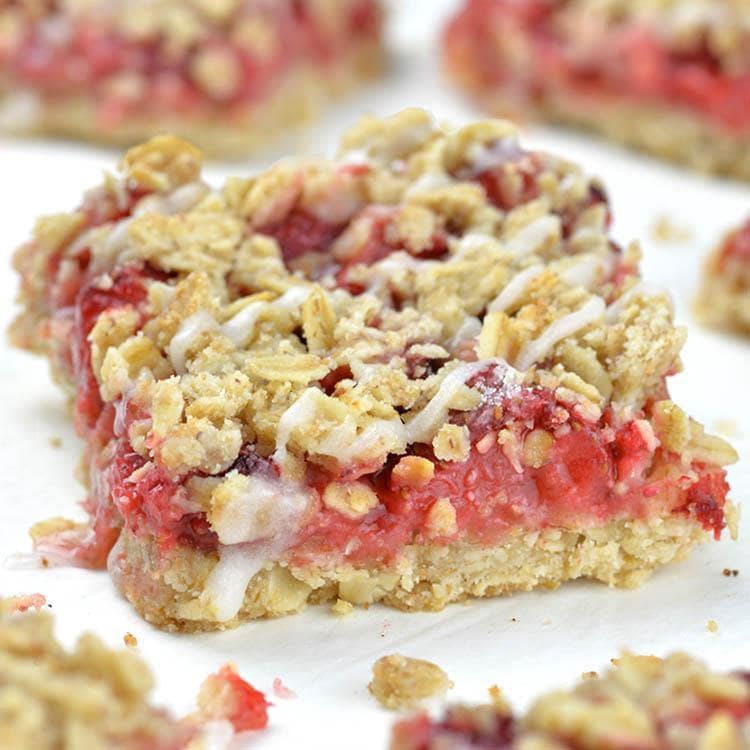 Big piece of strawberry oatmeal bar in front of two others.