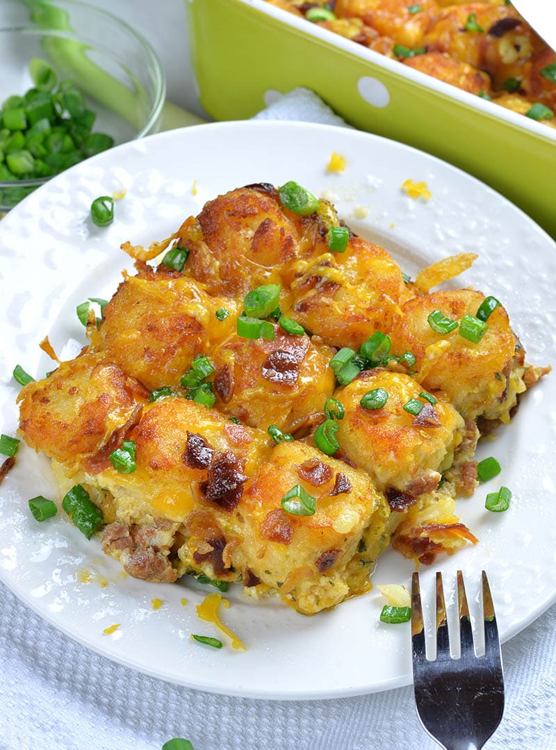 Piece of Tater Tot Casserole in a white plate with fork.