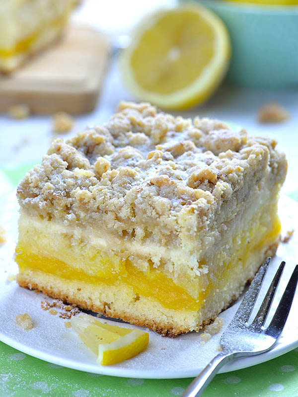 This tender and fluffy cake is super moist. It has a tart lemon curd layer in the center, cheesecake layer on top and irresistible, crunchy and buttery crumb topping!