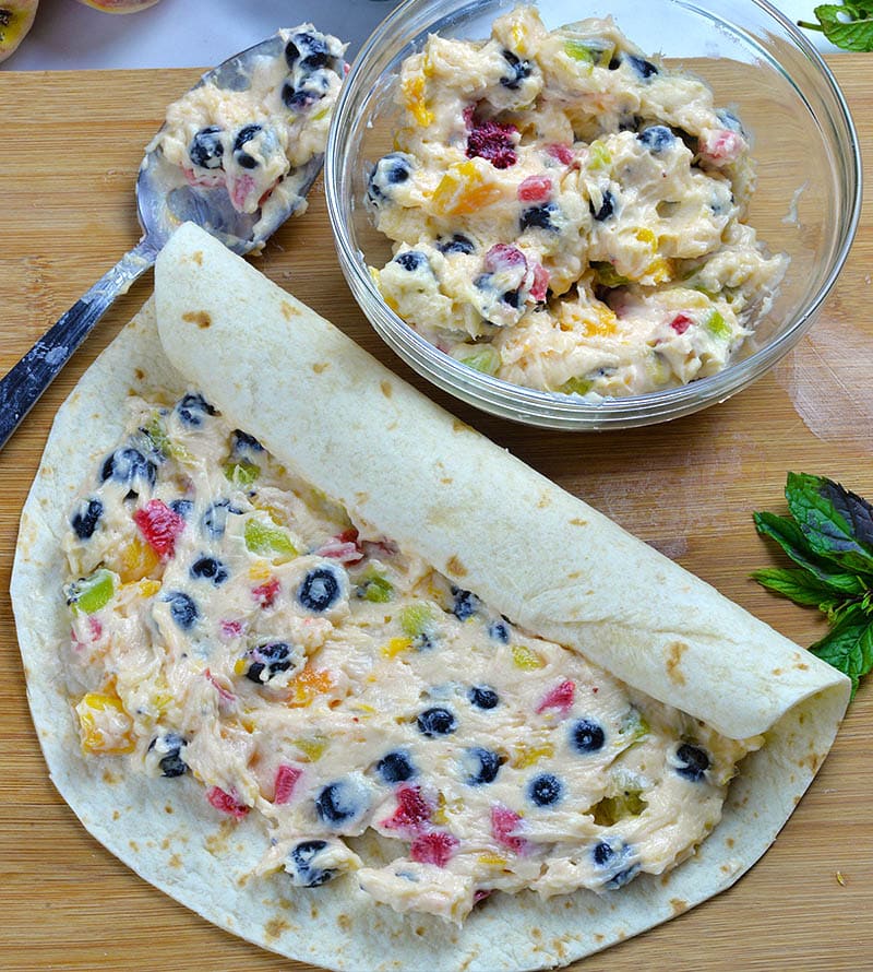 Tortilla with cheesecake fruit salad and fruit salad in a plate.
