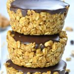 Three stacked peanut butter granola cups with chocolate on top