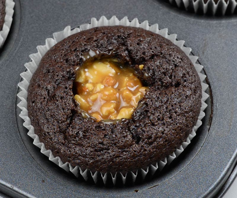 Baked chocolate cupcake filled with caramel peanuts.