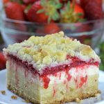 Big piece of Strawberry Coffee Cake on white plate in front of strawberry bowl.