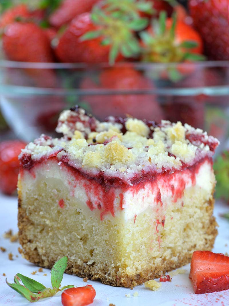 Piece of Strawberry Coffee Cake in front of strawberry bowl.