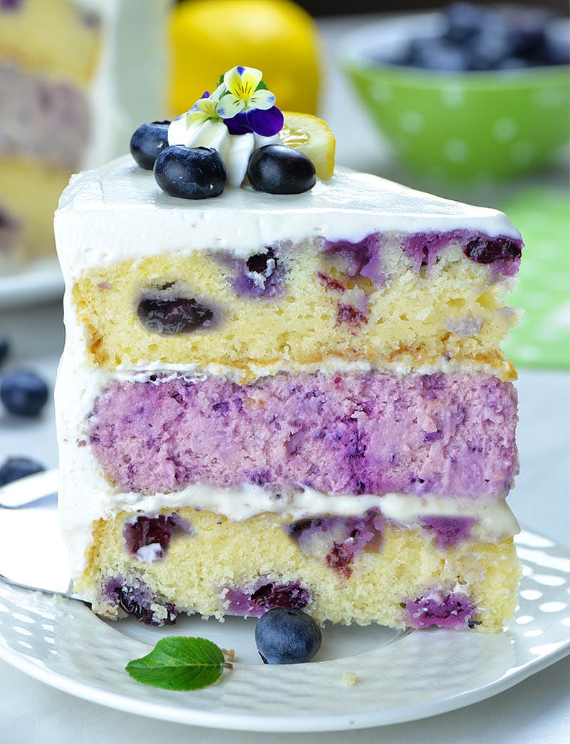 Piece of Lemon Blueberry Cheesecake Cake with there layers on a plate in side position.