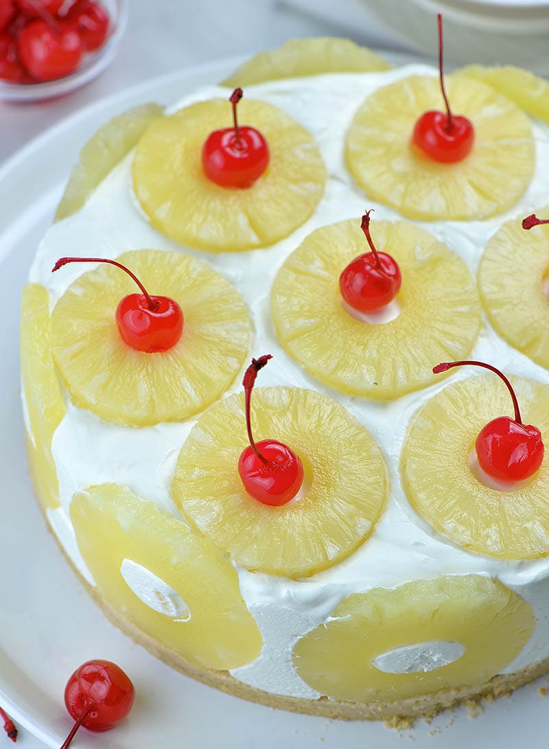 Pineapple cake garnished with pineapple slices and maraschino cherries.