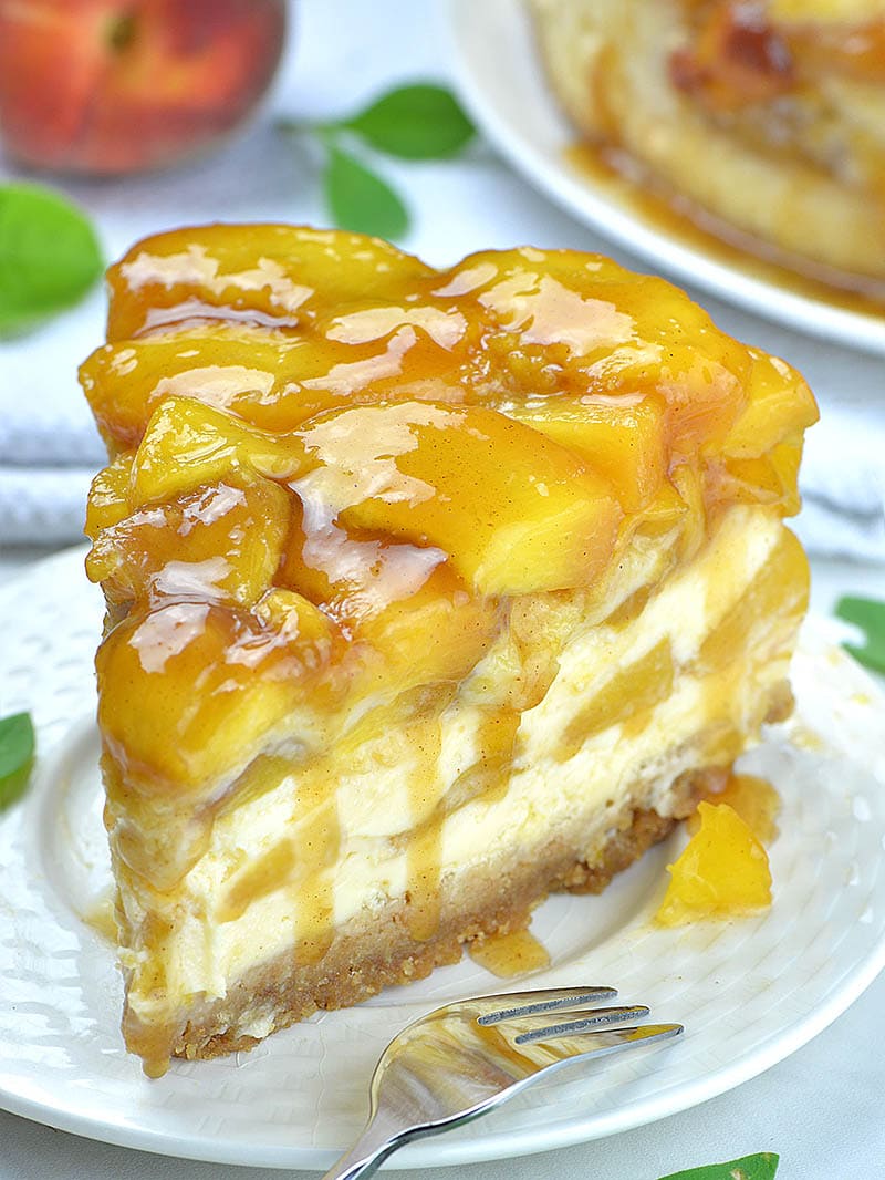 Slice of peach cobbler cheesecake on a plate.