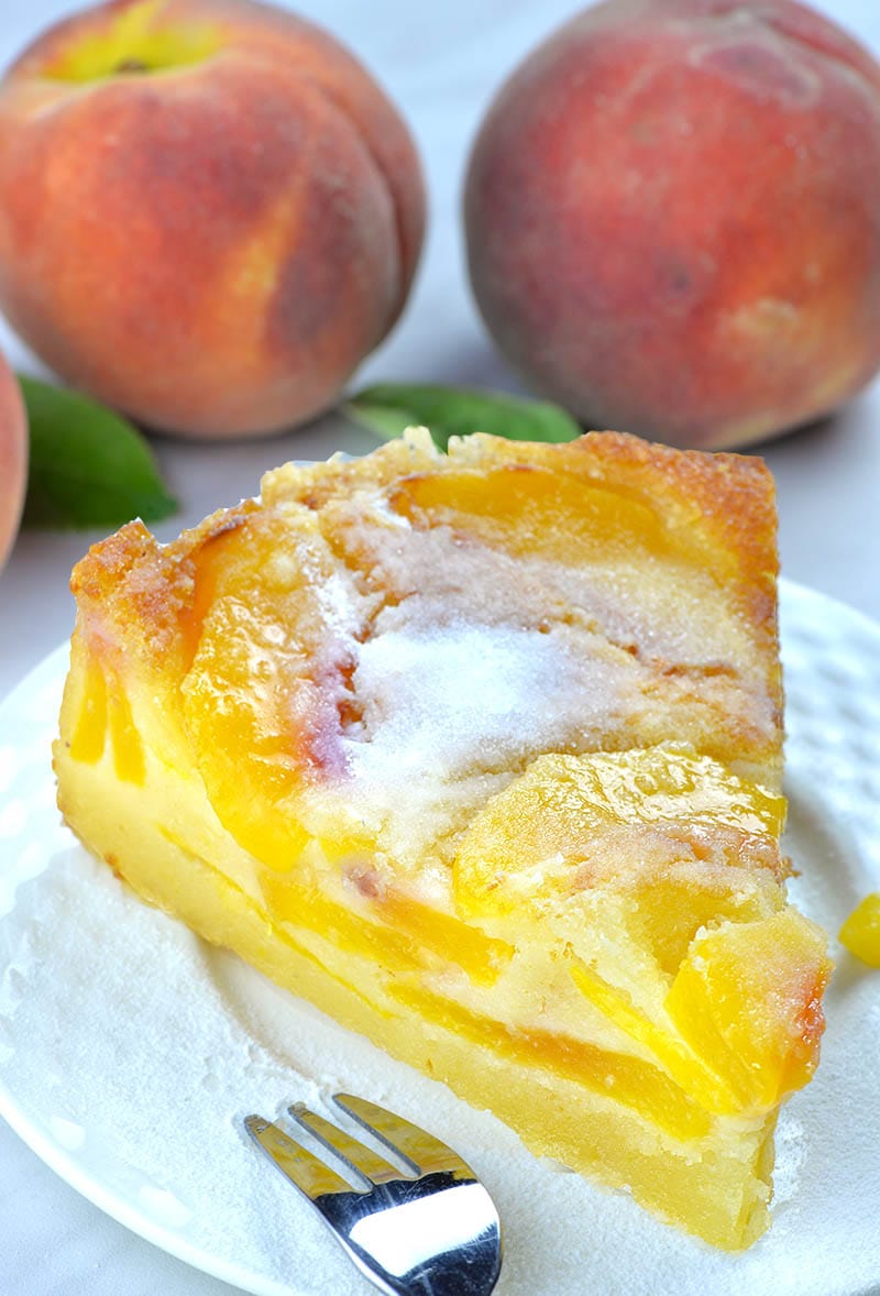 Easy peach cake served with powdered sugar on top!