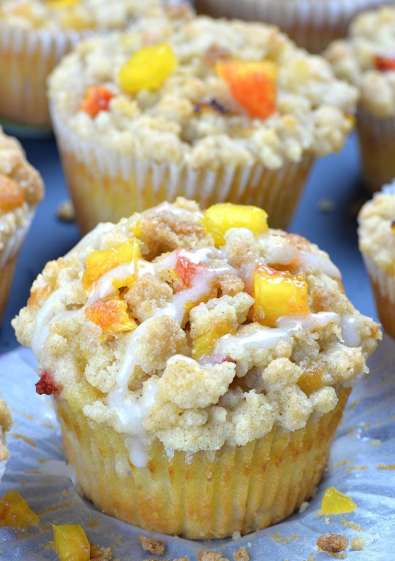 Baked peach muffins drizzled with vanilla glaze.