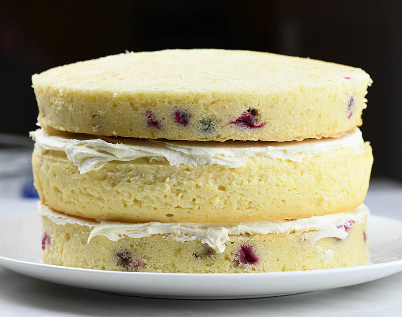 Two cranberry cake layers with cheesecake layer between.
