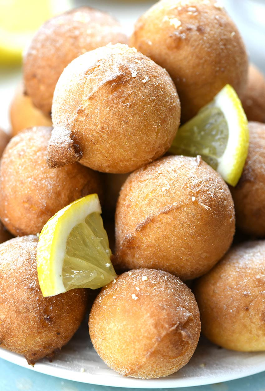 Bunch of Lemon Fritters garnished with small lemon pieces. 