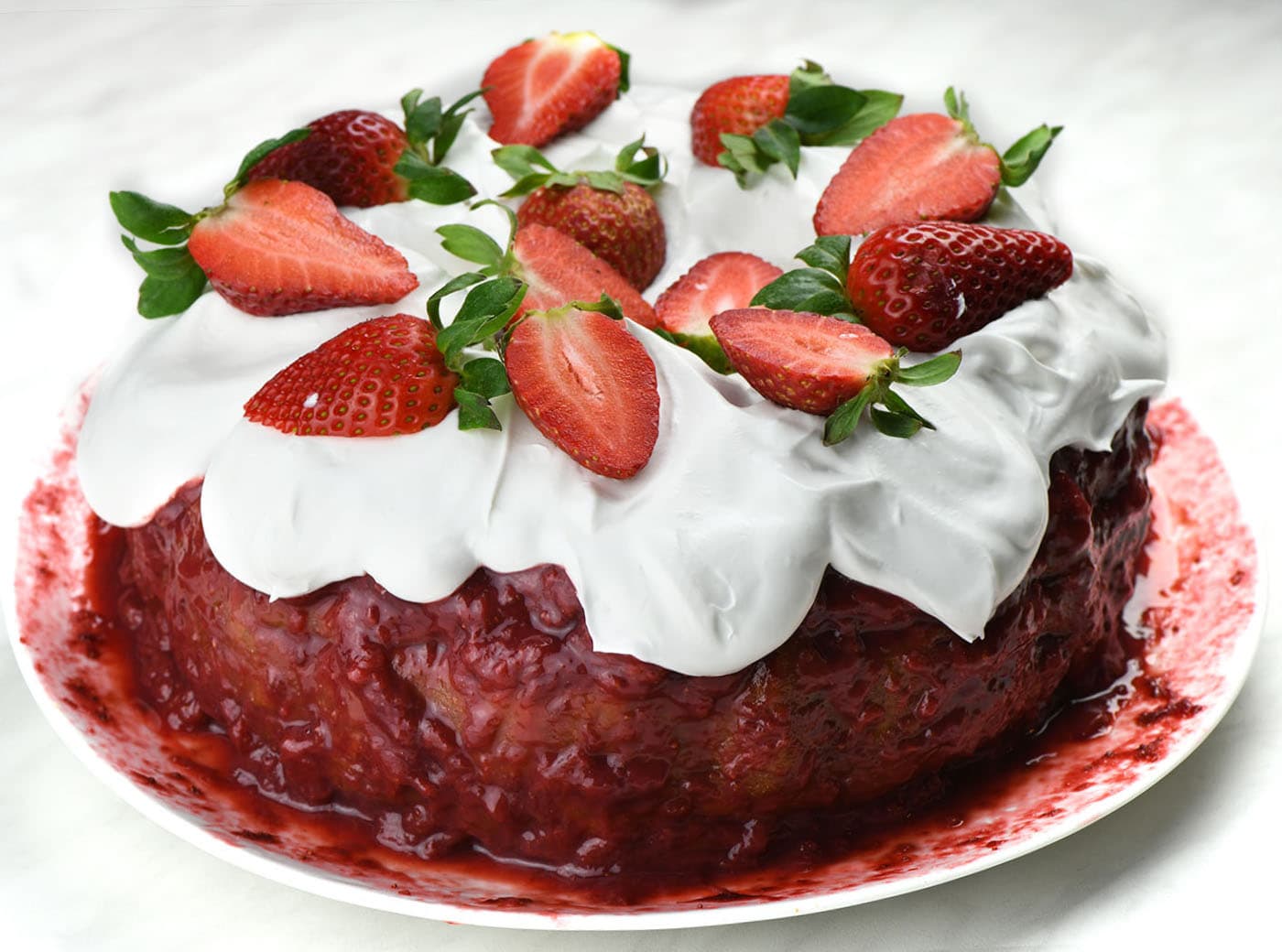 Whole Strawberry Bundt Cake on a white plate.