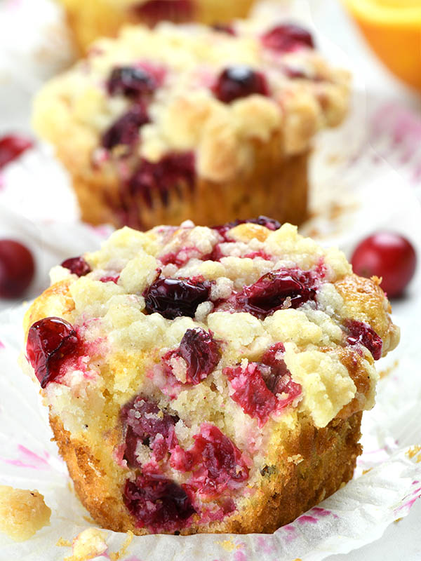 Cranberry Orange Muffin on parchment paper with couple of muffins overdue them.