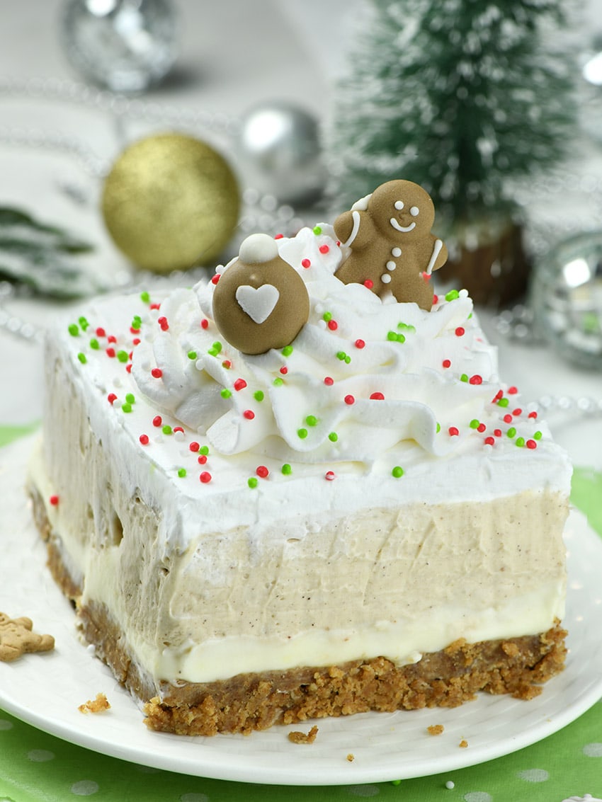 Slice of Gingerbread Lasagna on white plate with Christmas decoration behind.