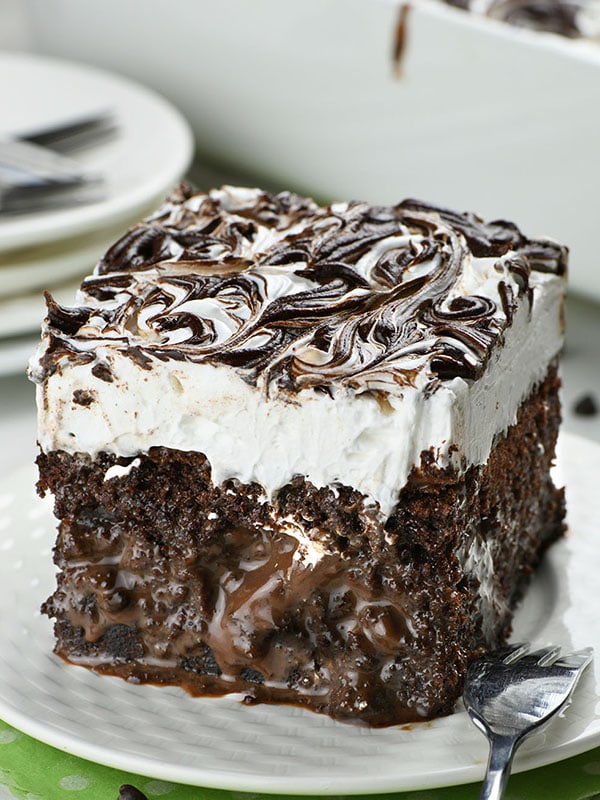 Piece of Marshmallow Chocolate Poke Cake on a white plate.