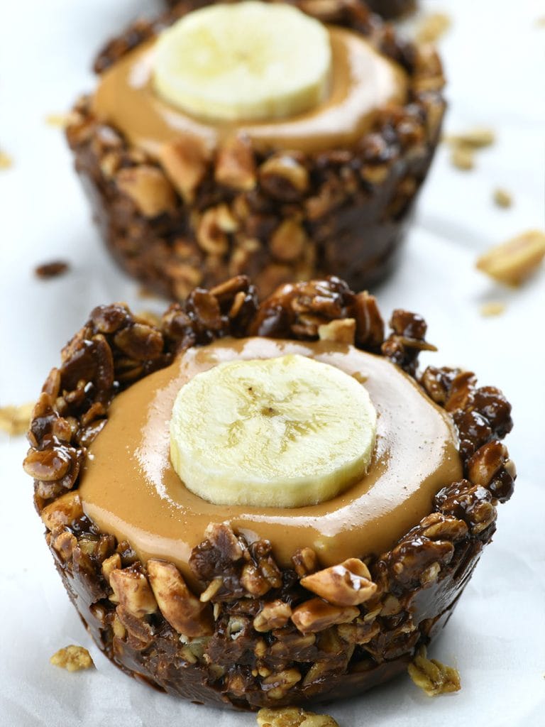 Chocolate Granola Cups filled with peanut butter and topped with banana slice.