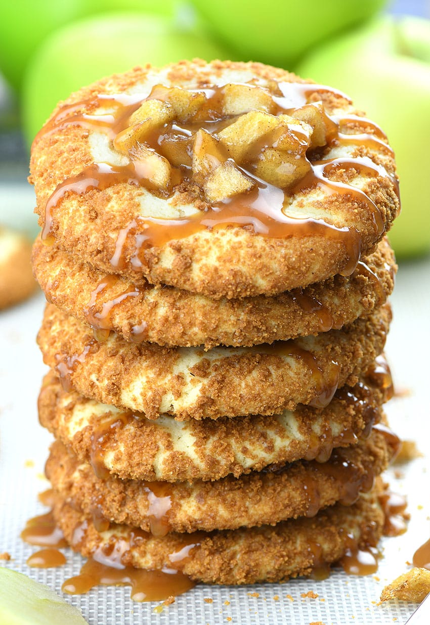 Bunch of Apple Pie Cheesecake Cookies with couple of green apples behind.