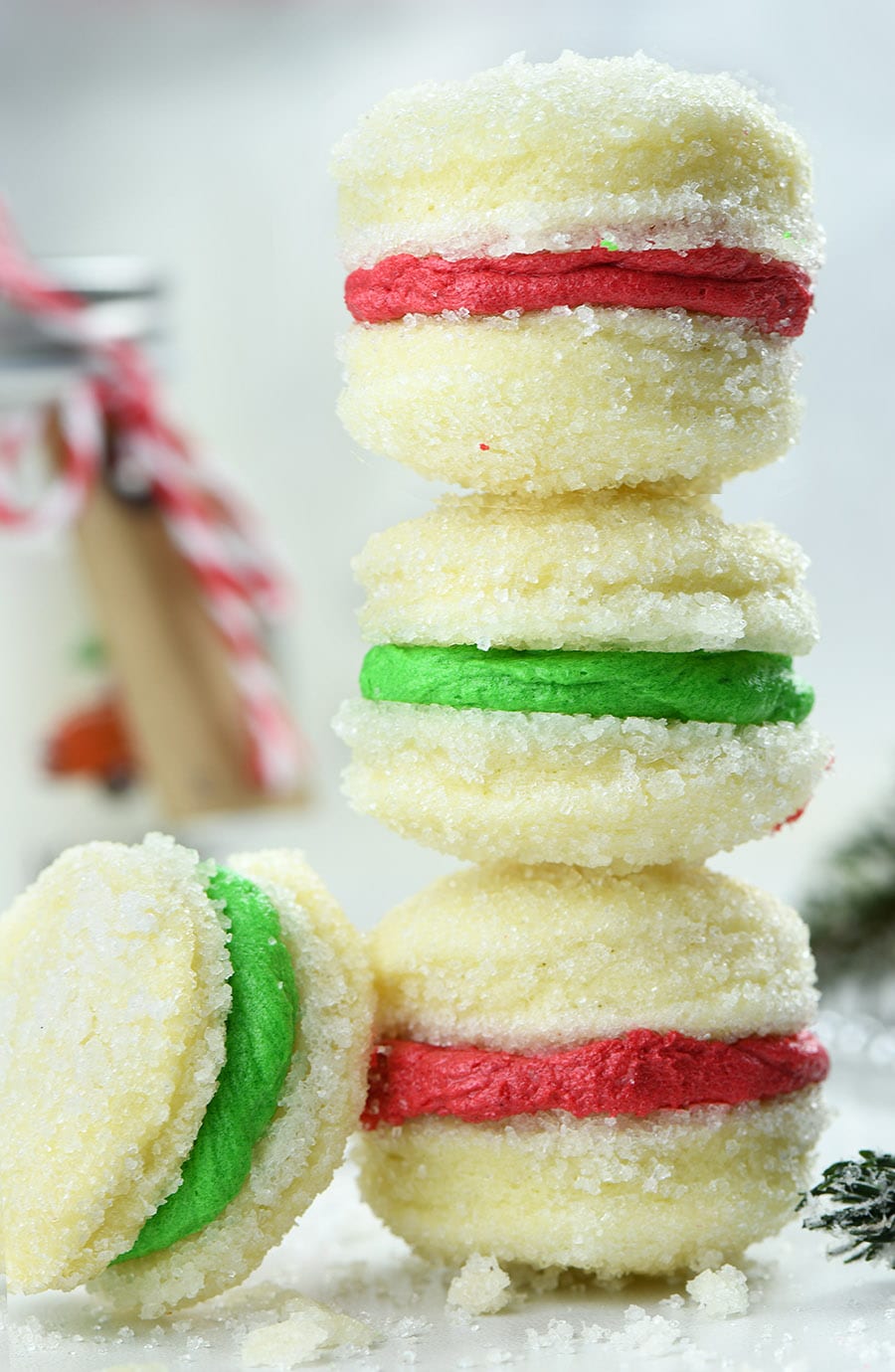 Three Christmas Shortbread Sandwich Cookies with Christmas decorations.