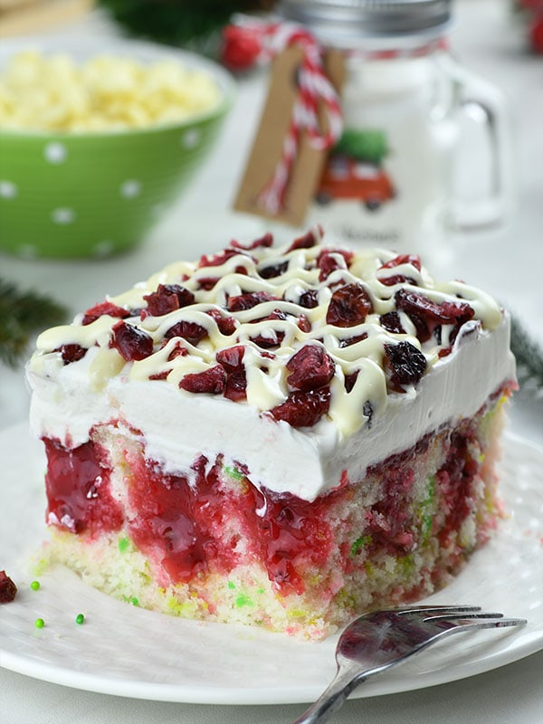 Cranberry Poke Cake - the creamy sweetness of cream cheese whipped frosting, contrasting with bright cranberry tang