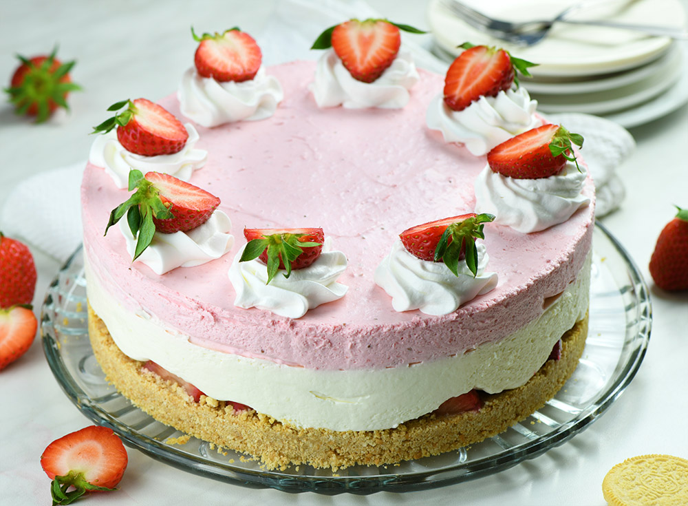 Whole Layered No-Bake Strawberry Cheesecake on a cake plate.