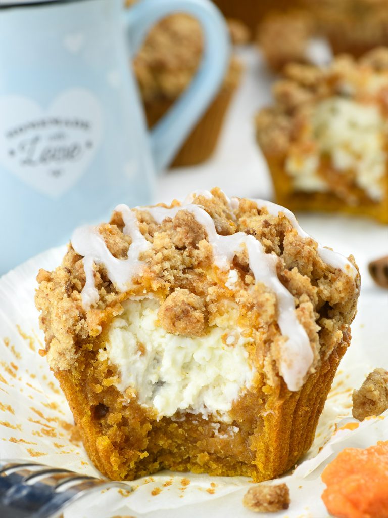 Bitten cream cheese pumpkin muffin on baking paper