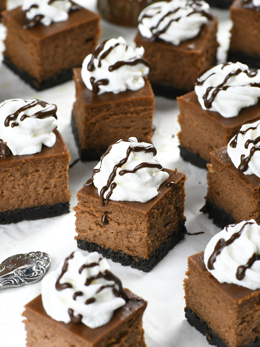 Bunch of Chocolate Cheesecake Bites topped with whipped cream and chocolate.