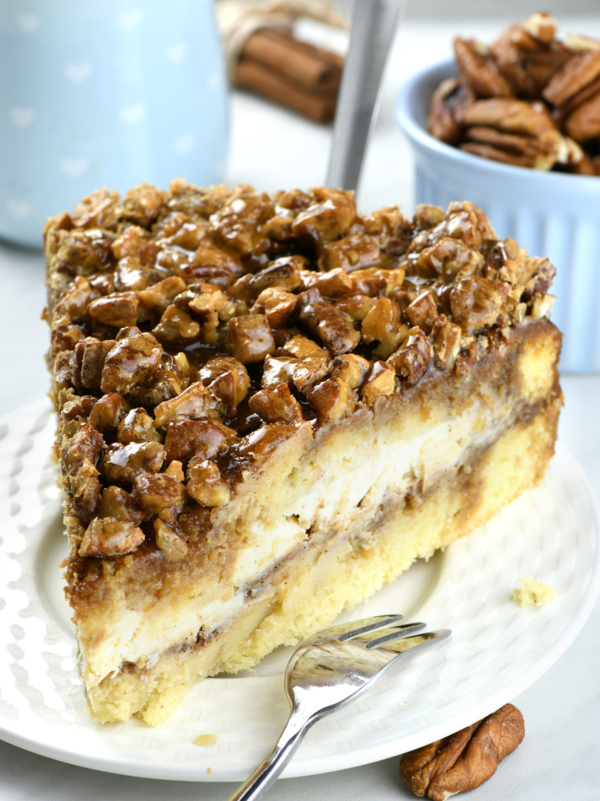 Side view of Piece of Pecan Pie Cheesecake Coffee Cake on a white plate.