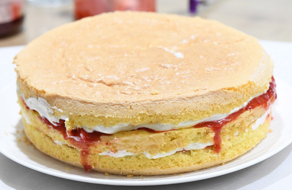Unassembled strawberry cake. It consists of two layers of golden yellow sponge cake. 