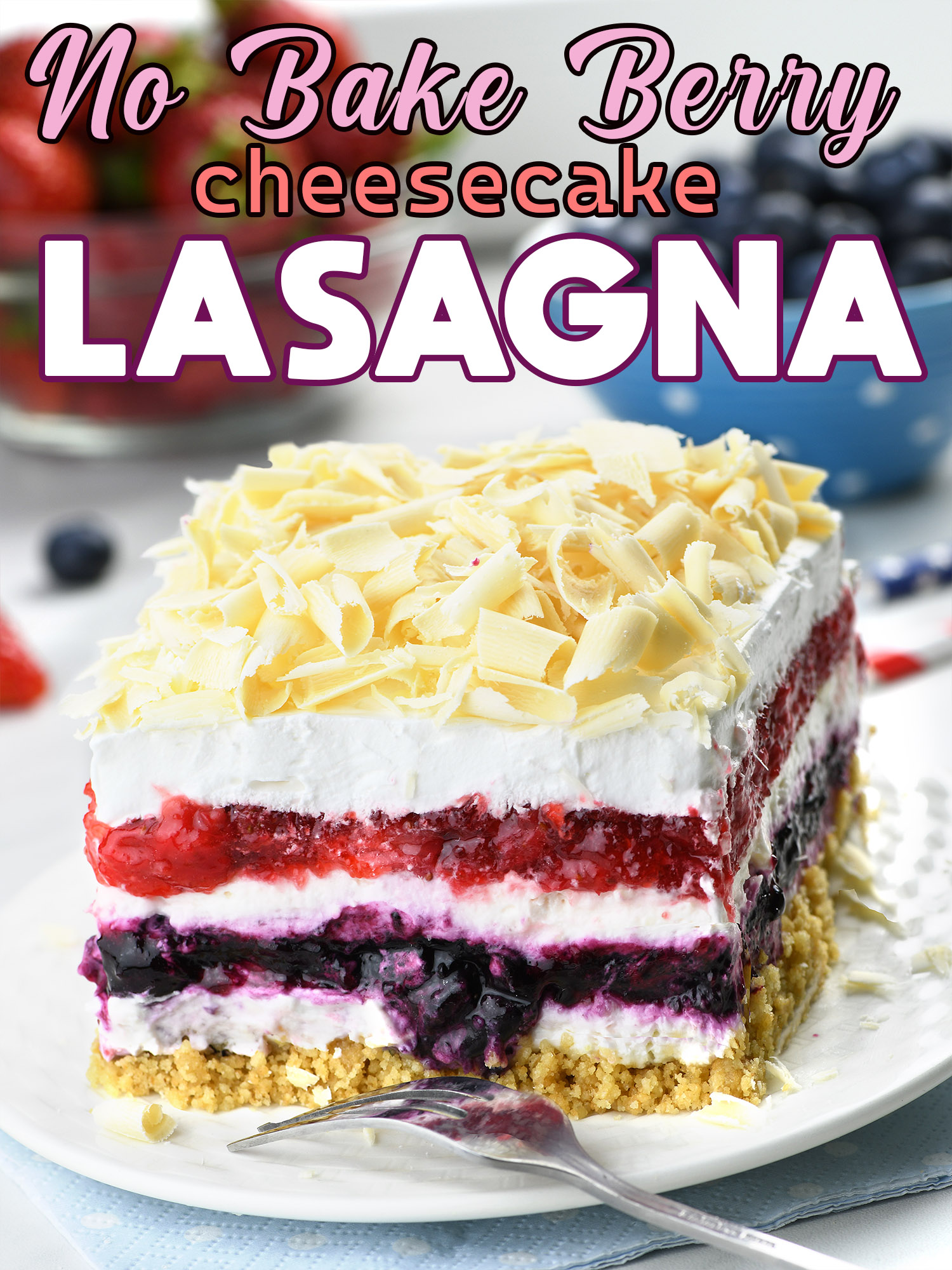 Delicious layered dessert featuring a no-bake berry cheesecake lasagna. The dessert has a crumbly base, layers of white cream, and vibrant red and purple berry layers, topped with white chocolate shavings.