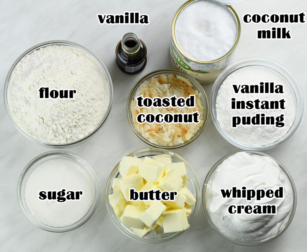 All the simple ingredients you need to make Coconut Cream Pie Cookie Cups: flour, sugar, butter, vanilla, coconut milk, vanilla instant pudding mix, whipped cream, and toasted coconut.